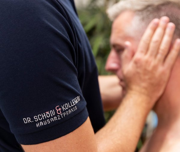 Ein Mann wird von einem Arzt mit manueller Medizin am Nacken behandelt